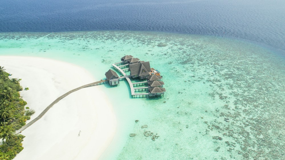 Aerial view of a beach and villas beside turquoise water